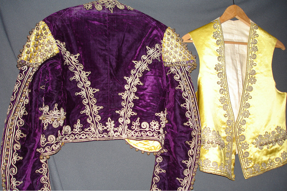 Matador jacket and vest, possibly a costume. Jacket: Purple velvet with metallic thread decoration. Vest: Yellow satin with metallic thread accents.